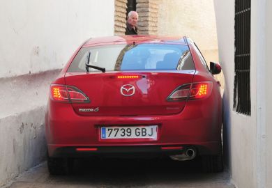 Red car stuck in alleyway, Córdoba, Spain Red car stuck in alleyway, Córdoba, Spain