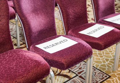Red rows of chairs with white sheets reserved