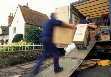 Removal men loading home contents into truck