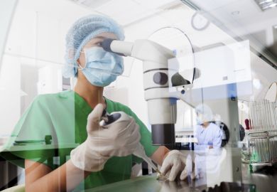 Researcher with microscope in lab