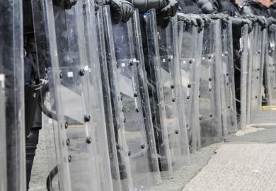 Police with riot shields illustrating the threat to higher education in Myanmar