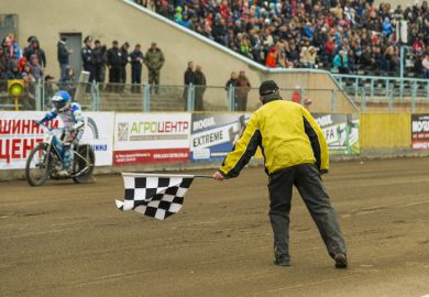 Rivne, Ukraine - 11 October 2015 Man with a checkered flag finish shows at the Open Cup Speedway to the day of the city Rivne