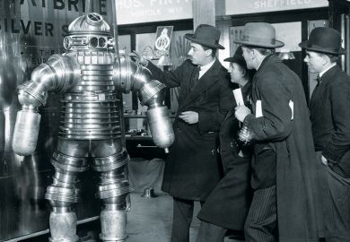 Men examining 1950s-style robot