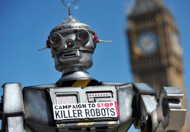 A robot wearing a sign saying 'Campaign to Stop Killer Robots’ A robot wearing a sign saying 'Campaign to Stop Killer Robots’