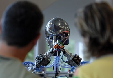 People watch a robot grapple with a Rubik's Cube