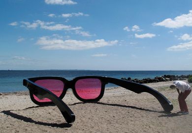 man looking through giant rose tinted sunglasses