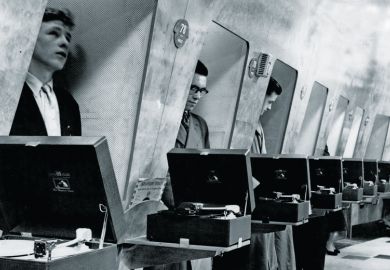 Row of men listening to vinyl records in turntable booths Row of men listening to vinyl records in turntable booths