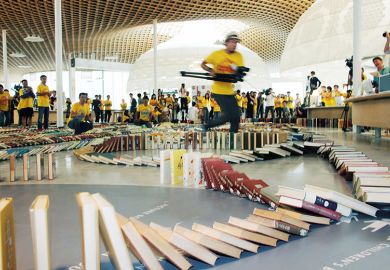 Running with camera to capture book domino chain