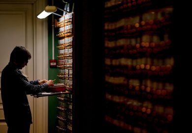 A man looking for items on the shelves (many of which are in the dark) in the Russian State Library in Moscow, Russia, 2018. To illustrate that a lack of archival access have transformed Russia studies