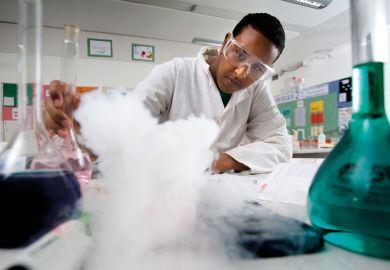 Science pupil performing experiment, Bristol City Academy