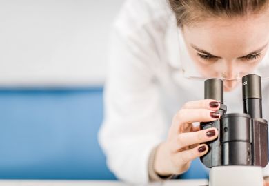 Scientist looking into microscope