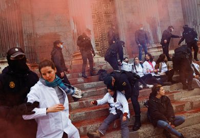 Police officers try to prevent Scientist Rebellion activists from throwing red paint at the exterior of the Spanish Parliament to protest climate change, in Madrid, Spain, April 6, 2022 Police officers try to prevent Scientist Rebellion activists from throwing red paint at the exterior of the Spanish Parliament to protest climate change, in Madrid, Spain, April 6, 2022