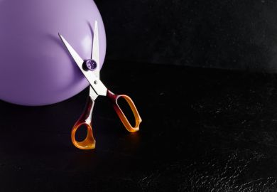 Scissors threatening to cut a balloon Scissors threatening to cut a balloon