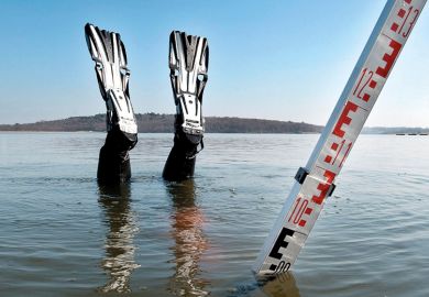 Scuba diver nose-diving into shallow water