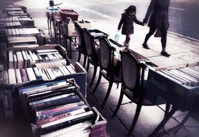 People walk past second hand books for sale
