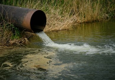 A pipe drains sewage into a river A pipe drains sewage into a river