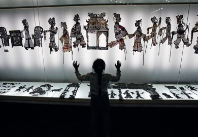 A visitor admires shadow puppets made of leather during an exhibition. China A visitor admires shadow puppets made of leather during an exhibition. China
