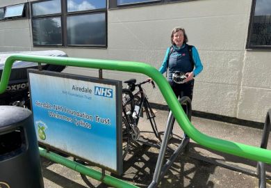 Shunna Burke after cycling to hospital , stood by NHS sign
