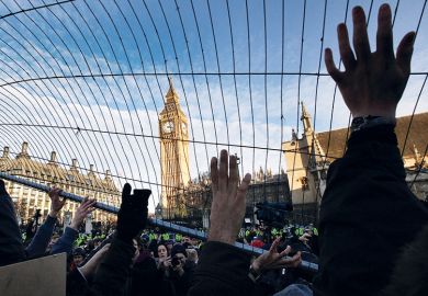 Student fees protesters attempt to throw a fence at police in Parliament Square in December 2010 in London