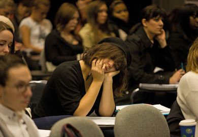 Woman sleeping in lecture theatre Woman sleeping in lecture theatre