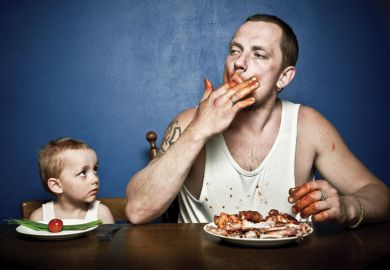 Small child and man eating at table