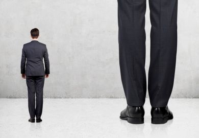 Small man standing next to giant