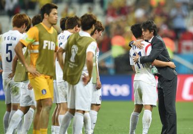 South Koreas football coach hugs one player