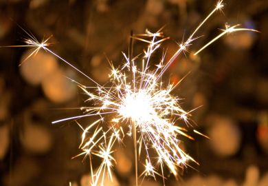 A sparkler held in someone’s hand A sparkler held in someone’s hand