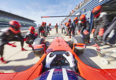 Technicians change the tyres of a racing car, symbolising support for spinouts