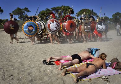 Sunbathers watch Italian re-enactors dressed as Greek hoplites perform the 490 BC battle of Marathon Sunbathers watch Italian re-enactors dressed as Greek hoplites perform the 490 BC battle of Marathon