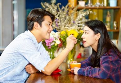 A man spoon-feeding a woman