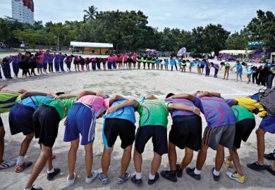 Sports team gathered in huddle at school sports event