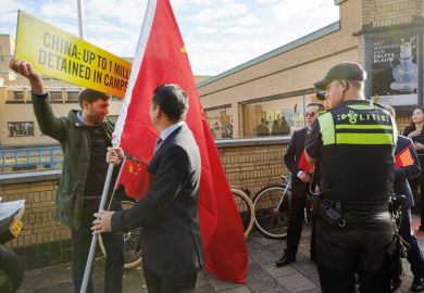 Supporters of Chinese Prime Minister Li Keqiang attempt to block an activist of Amnesty International holding a protest with a Chinese flag to illustrate VU Amsterdam row ‘shows need for clear policies’ on China ties