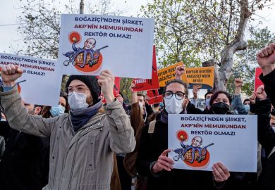 Students wearing face masks hold placards during the demonstration to illustrate Bog˘aziçi students and staff fear reprisals after deans sacked