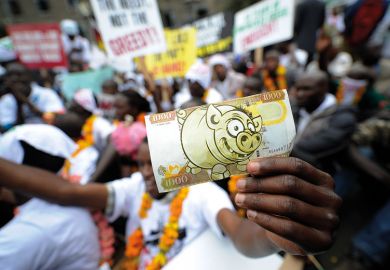 Protesters hold a fake bill imitation of local currency during a demonstration to illustrate Visa money-lending scams ‘commonplace’, warns ex-minister
