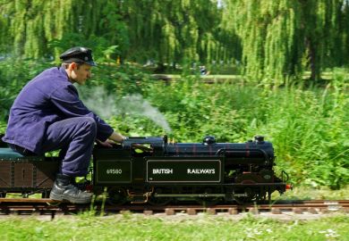 St Neots, Cambridgeshire, England - May 05, 2022 Miniature Steam train and driver in the park.