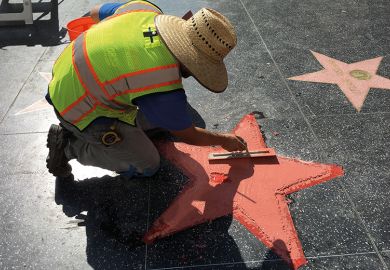 A worker repairs a star on the Hollywood Walk of Fame