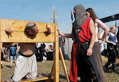 A man in stocks at a modern-day fete