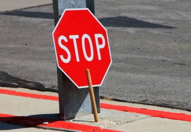 Stop sign rested against street sign pole
