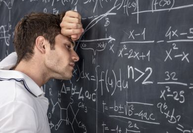 A stressed lecturer leans against a blackboard