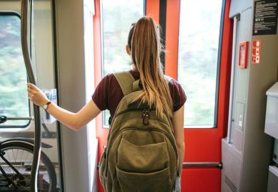 student with a backpack waiting for the train to stop to go outside