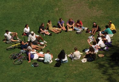 Students sitting in circle outside on lawn
