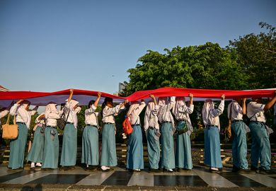 Students unfurl a long flag in Indonesia's national colours as they parade through the streets during a ceremonial event to mark Indonesia's 80th Independence Day in Surabaya on 17 August, 2025.