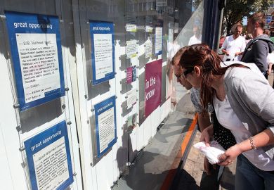 Students look at job vacancies on display in the window to illustrate ‘Radical rethink’ needed as work vies with study