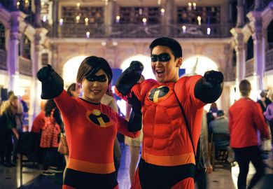 A male and female pose in matching costumes featuring characters from the film The Incredibles