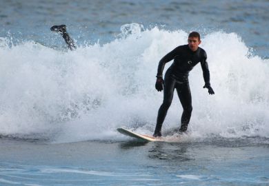 Surfer wiping out in small wave, Aberdeen Beach, Scotland