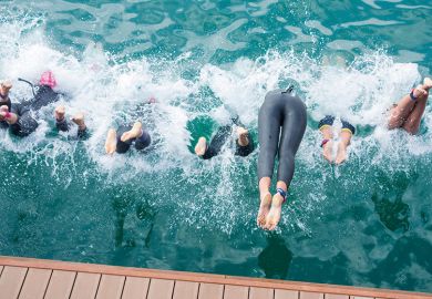 Swimmers diving into water