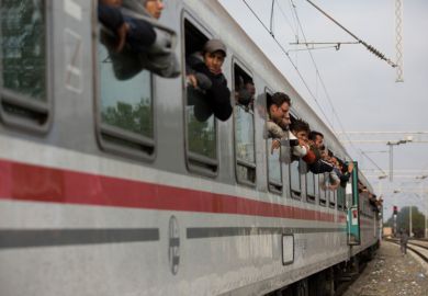 Syrian refugees leaning out of train windows