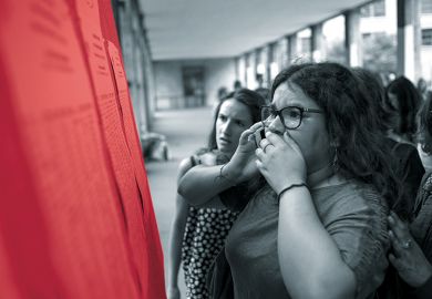 A woman on a mobile phone looks anxiously at a set of results on a board
