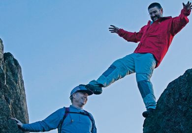 Man standing on another man's head
